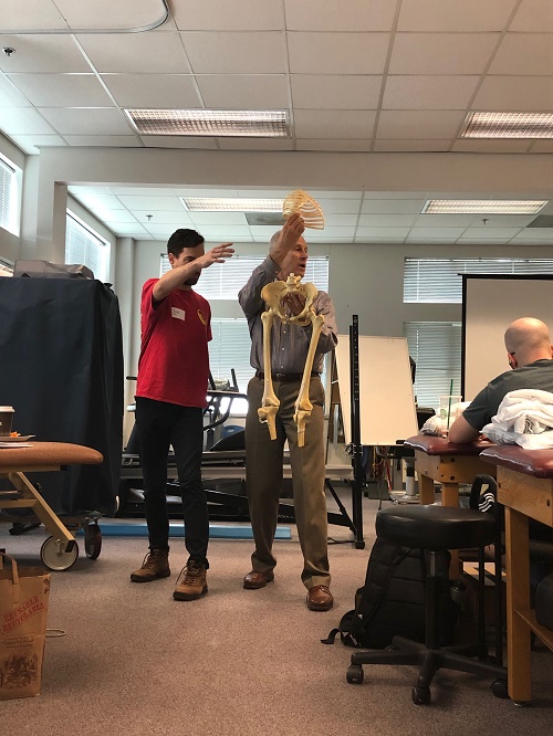 Skip George demonstrating thoracic rotation at a Postural Restoration course